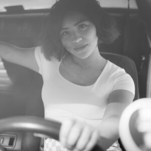 Black and white portrait of a woman sitting in a vintage car, Los Angeles.