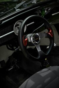 Close-up view of a vintage car's steering wheel, showcasing classic design and style.