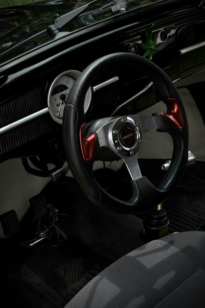 Close-up view of a vintage car's steering wheel, showcasing classic design and style.